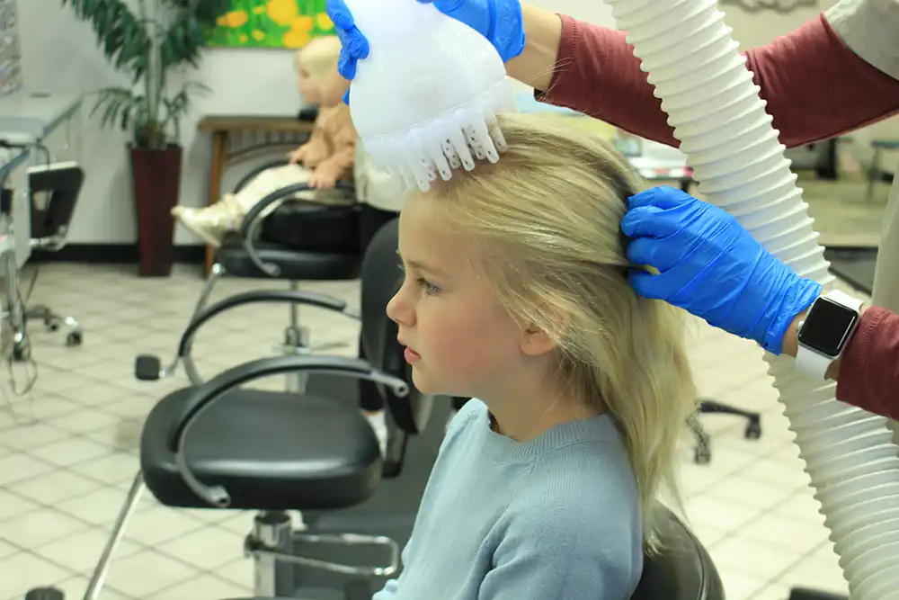 Child receiving Flosonix heated air treatment at Lice Beware clinic
